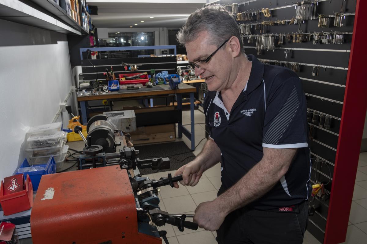 Locksmith cutting keys on a workshop key cutting machine