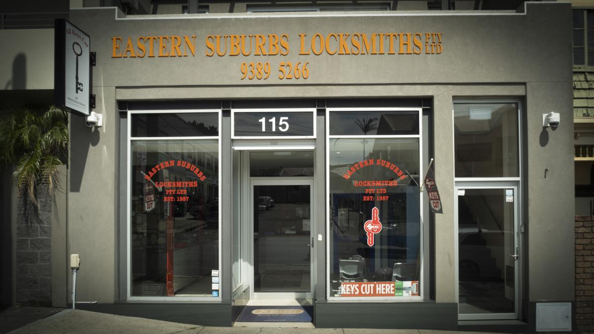 Street-facing Eastern Suburbs Locksmiths shopfront with glass doors, signage and key cutting display.