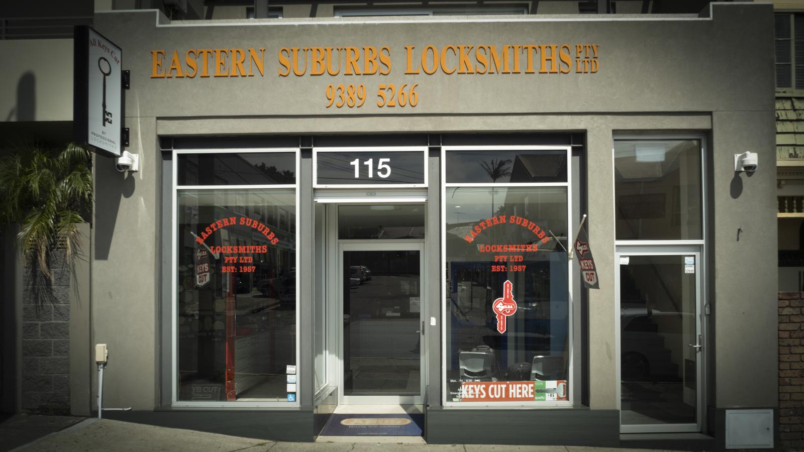 Street-facing Eastern Suburbs Locksmiths shopfront with glass doors, signage and key cutting display.