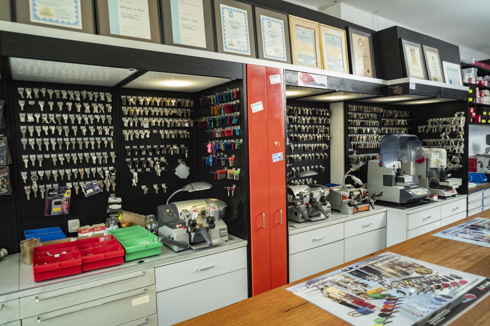 Locksmith shop counter with key cutting machines, key blanks and security products on display