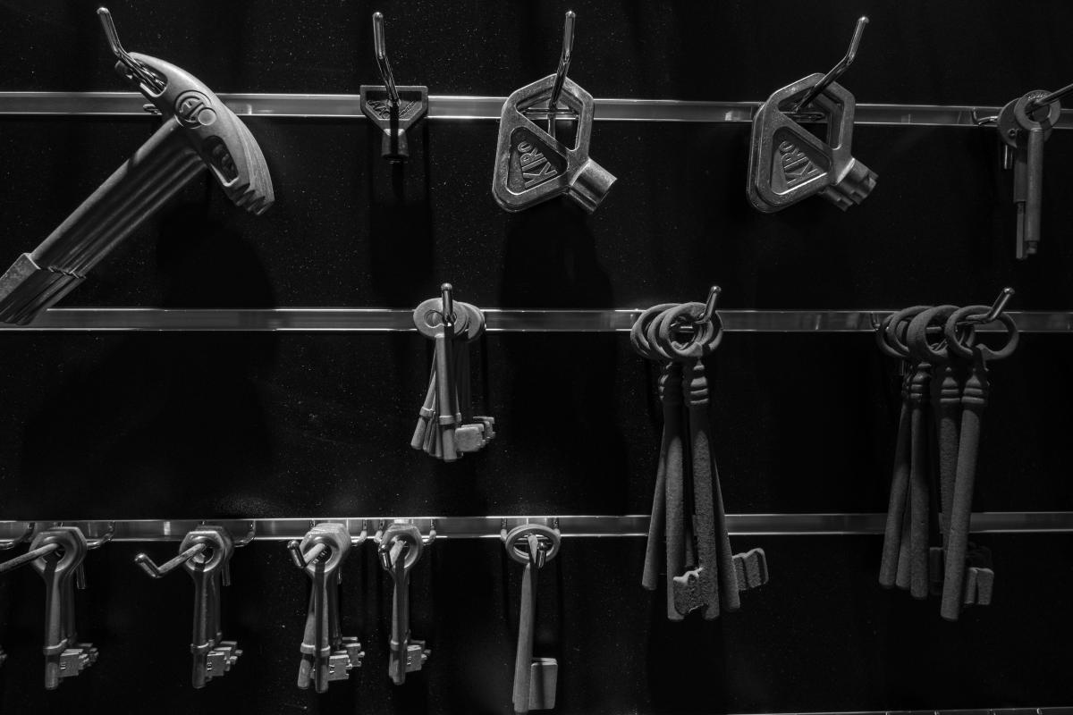 Assorted keys hanging on display rails in a locksmith workshop