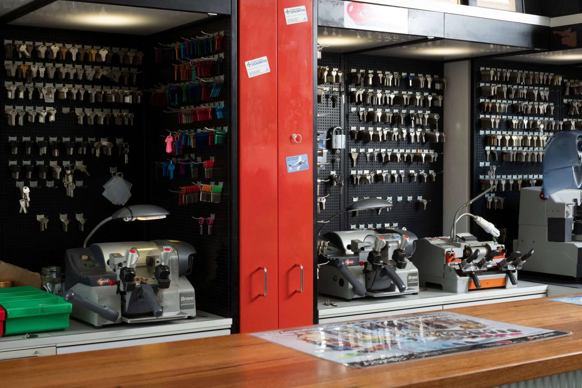 Locksmith shop counter with key cutting machines and organised key blanks on display